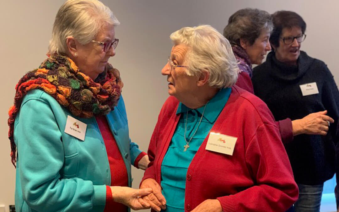 Two elderly women speaking to each other