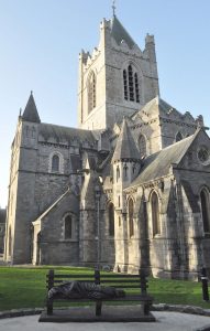 cathedral in Dublin with park bench and sculpture of homeless jesus.