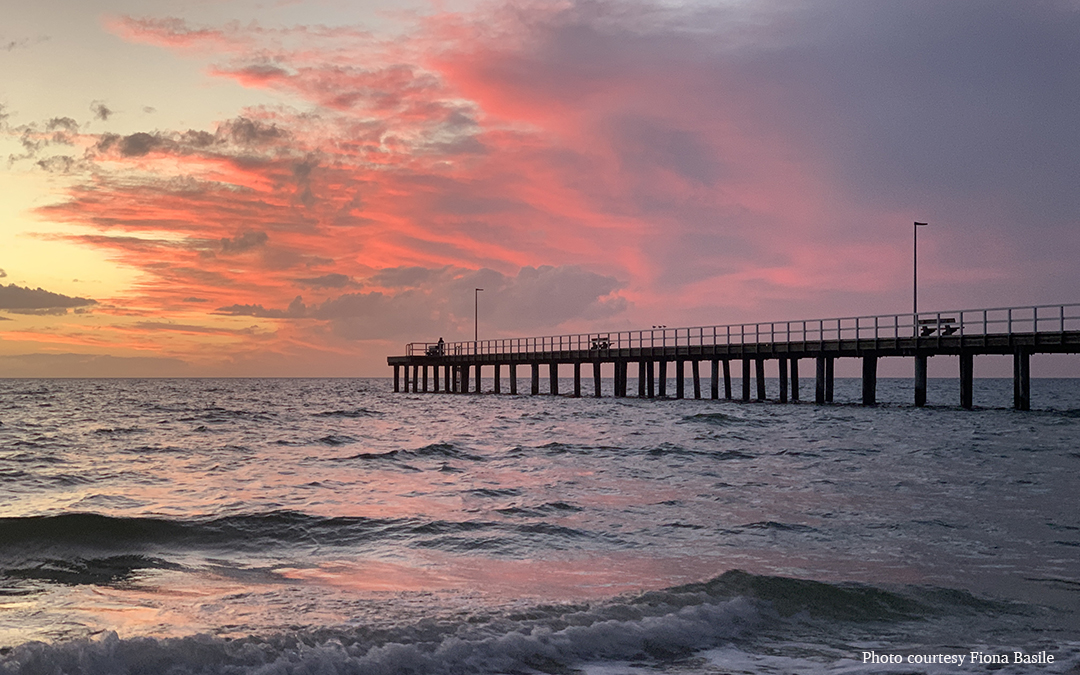 pink sunset over pier and water