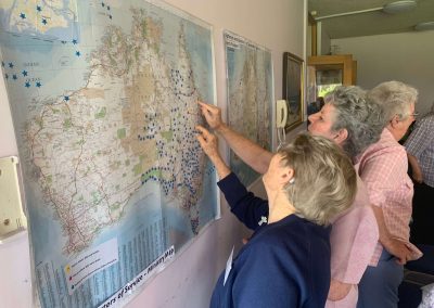 two women looking at map of australia on the wall