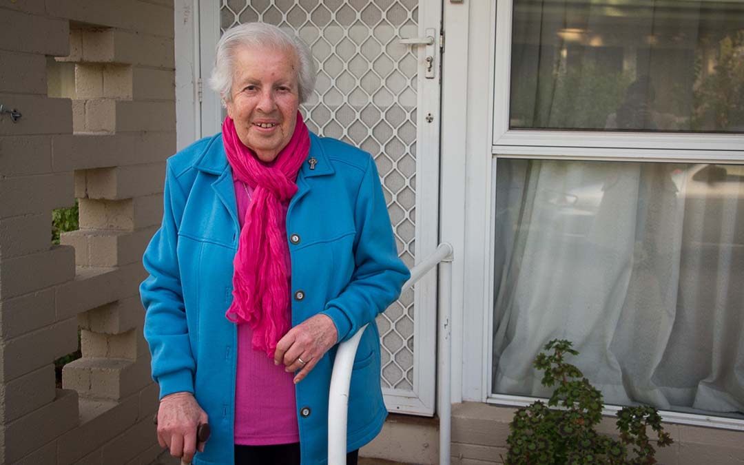 Older woman standing in front of door