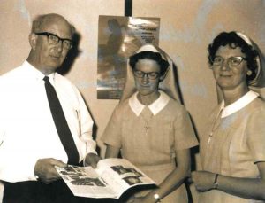 Man standing next to two nuns