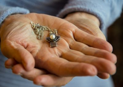 Hands holding necklace pendant with pearl