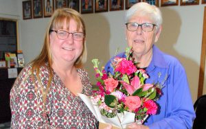 Two women holding bunch of flowers