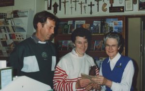 Woman standing with couple in book shop