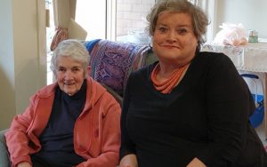 Two women seated on chairs looking at camera