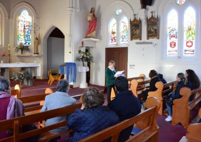 Woman reading to group of people in Church