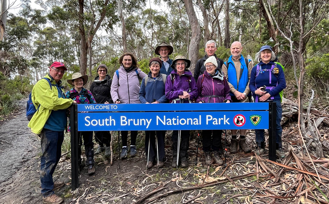 Hikers standing in front of national park sign