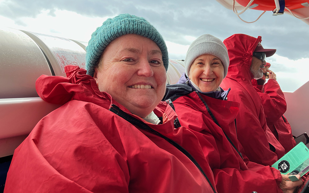 Women in beanies and jacket on boat
