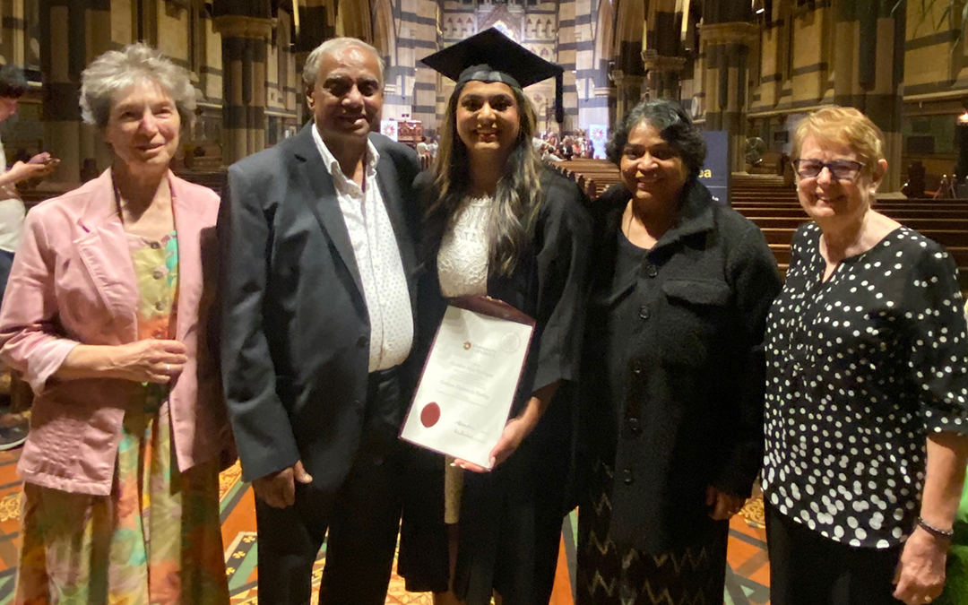 Young woman in graduation garb surrounded by family