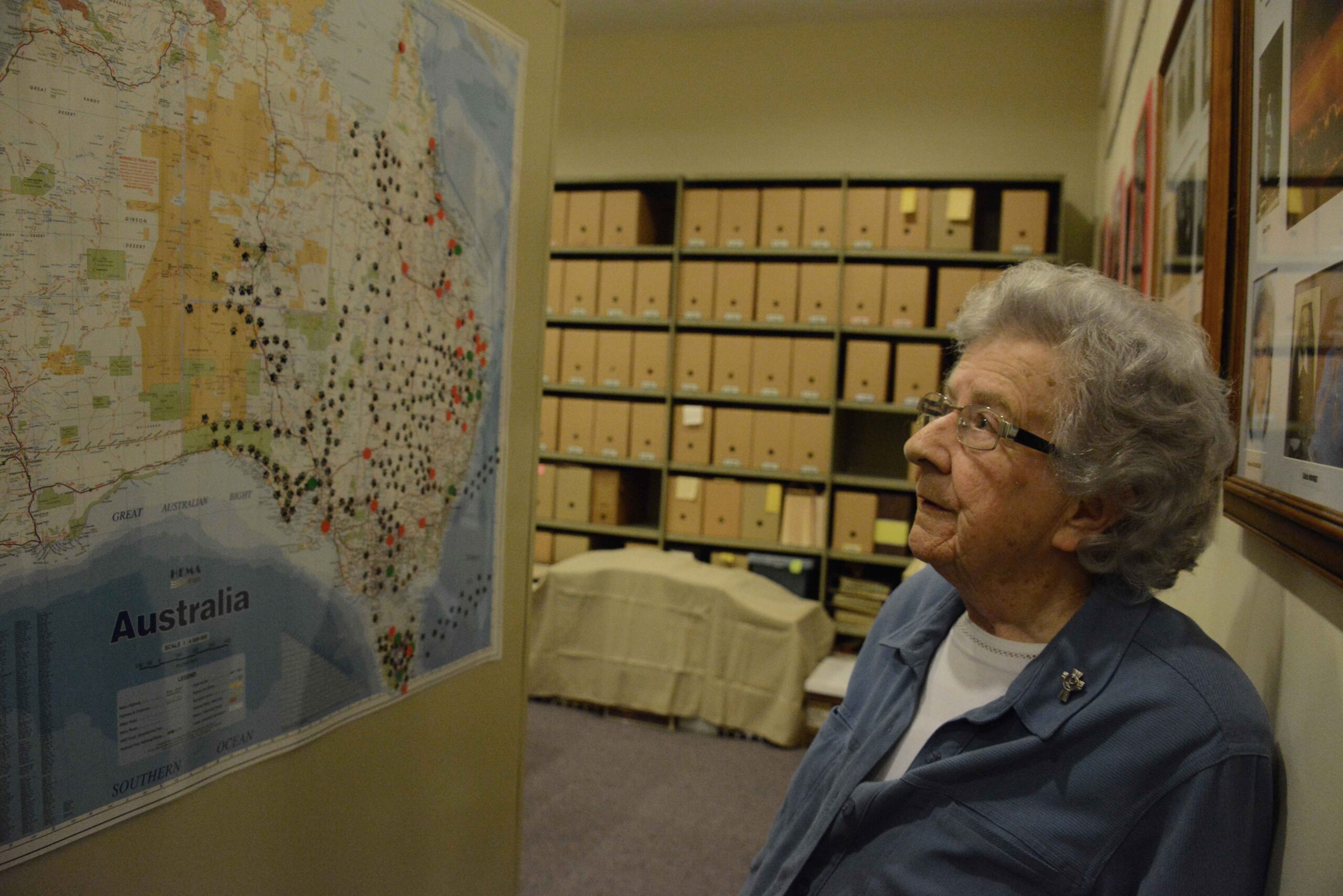 Woman in archive room looking at map Carmel Hall MSS