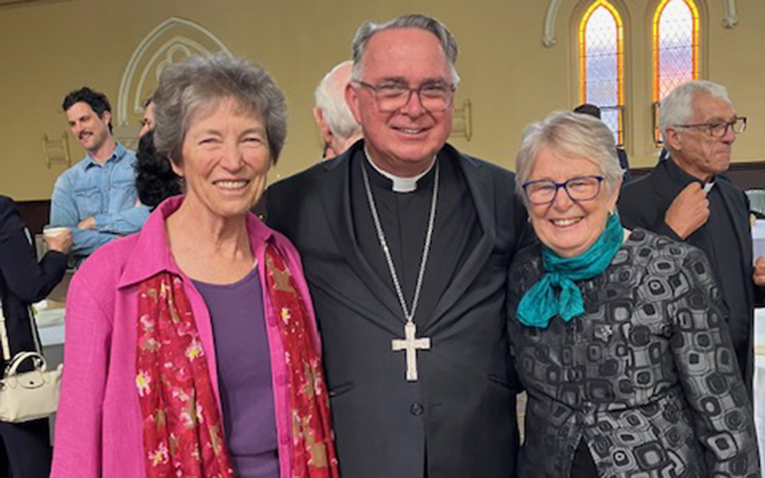 Three people in a row Bishop Mark Freeman